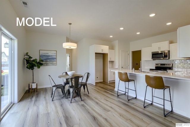 dining room featuring sink and light hardwood / wood-style flooring