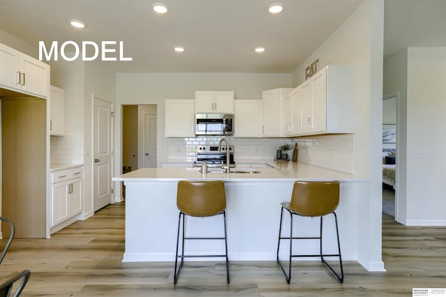 kitchen with sink, white cabinetry, and stainless steel appliances