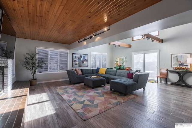 living room with rail lighting, hardwood / wood-style flooring, a brick fireplace, and wood ceiling