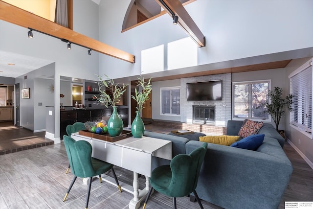 living room featuring a fireplace, wood-type flooring, and a high ceiling