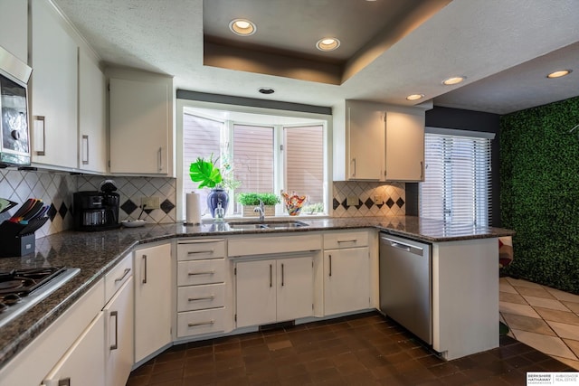 kitchen featuring white cabinets, a raised ceiling, sink, and appliances with stainless steel finishes