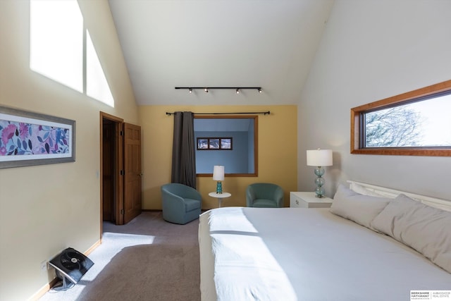 bedroom featuring light carpet, high vaulted ceiling, and track lighting