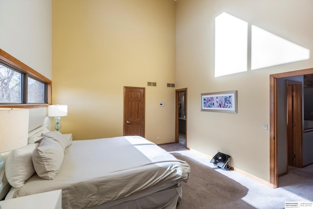 bedroom featuring a high ceiling and light colored carpet