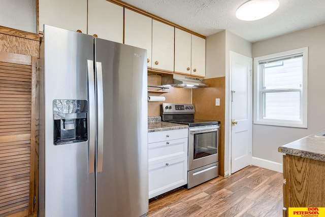 kitchen featuring light hardwood / wood-style flooring, white cabinets, a textured ceiling, and appliances with stainless steel finishes