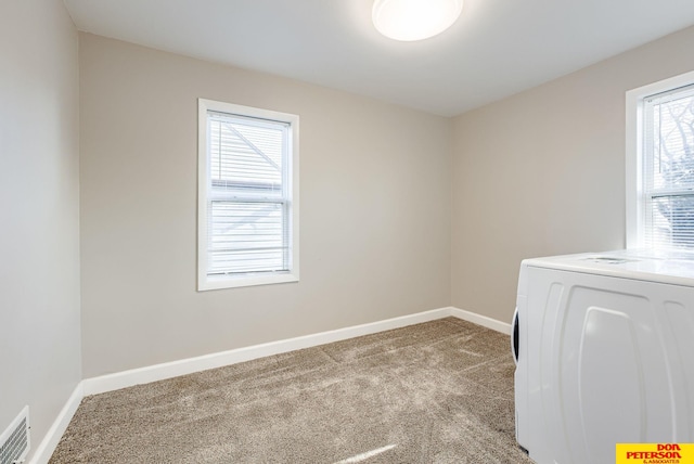 clothes washing area featuring washer / clothes dryer and light carpet