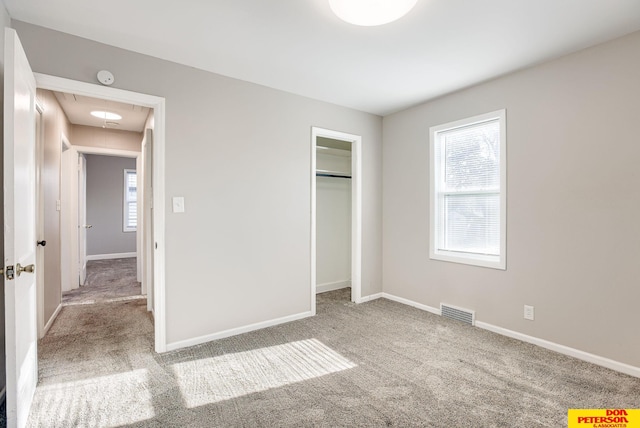 unfurnished bedroom featuring multiple windows, a closet, and carpet