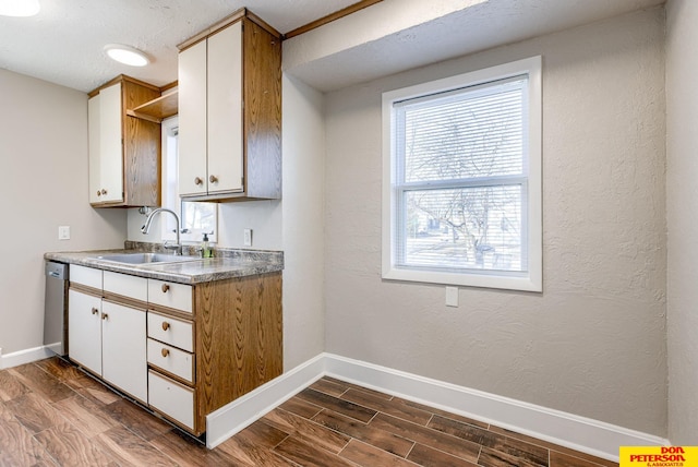 kitchen featuring dishwasher, sink, white cabinets, and dark hardwood / wood-style floors