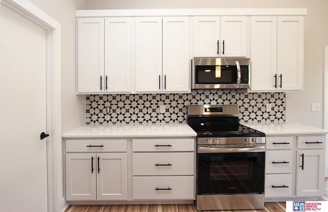 kitchen with white cabinetry, stainless steel appliances, and decorative backsplash