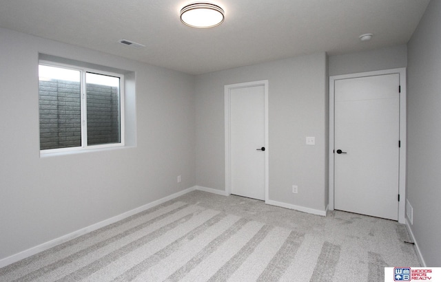 unfurnished bedroom featuring light carpet