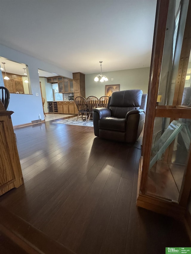 living room with dark hardwood / wood-style flooring and a notable chandelier