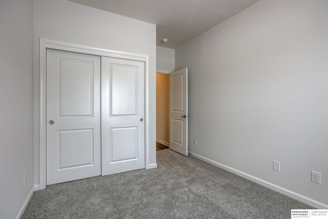 unfurnished bedroom with light carpet and a closet