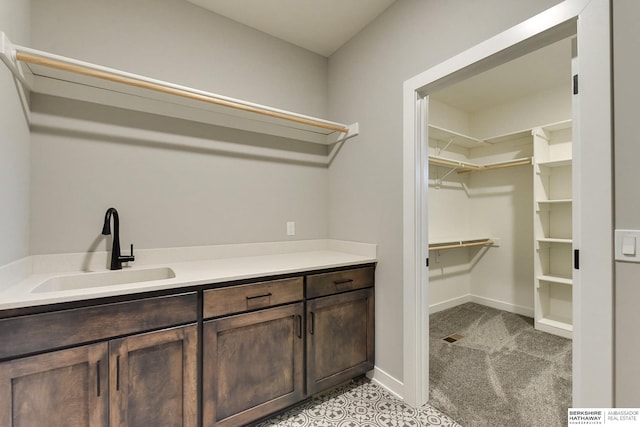 clothes washing area with sink and light carpet