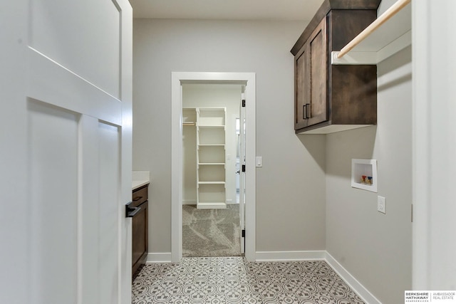 clothes washing area with cabinets and hookup for a washing machine