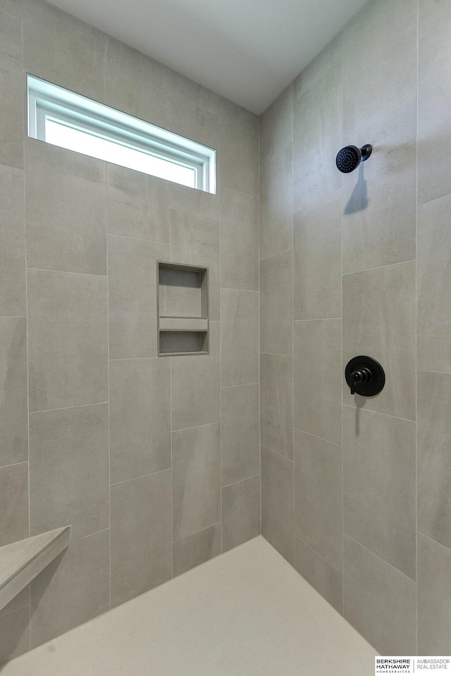 bathroom featuring a healthy amount of sunlight and tiled shower