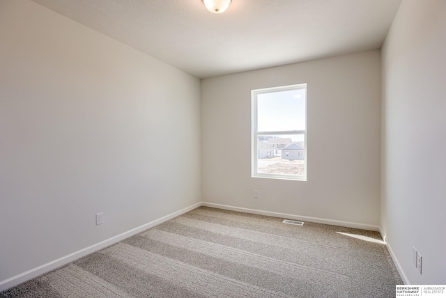 unfurnished room with visible vents, baseboards, and light colored carpet