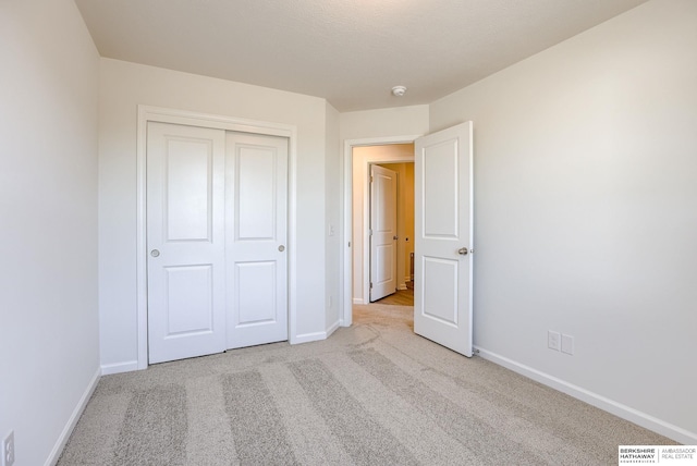 unfurnished bedroom with a closet, visible vents, baseboards, and carpet