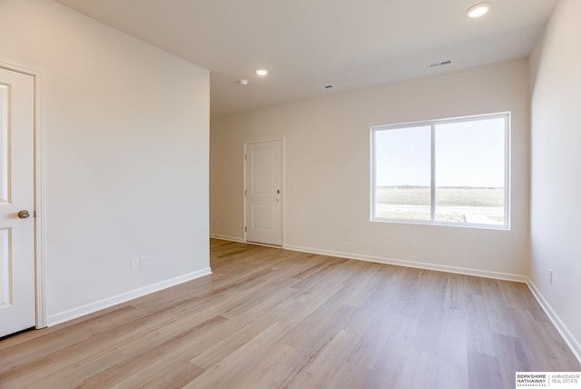 unfurnished room with recessed lighting, visible vents, light wood finished floors, and baseboards