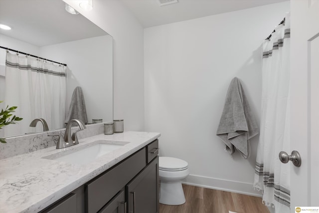 bathroom featuring vanity, wood-type flooring, and toilet