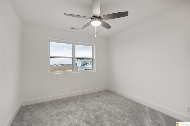 spare room featuring light carpet and ceiling fan