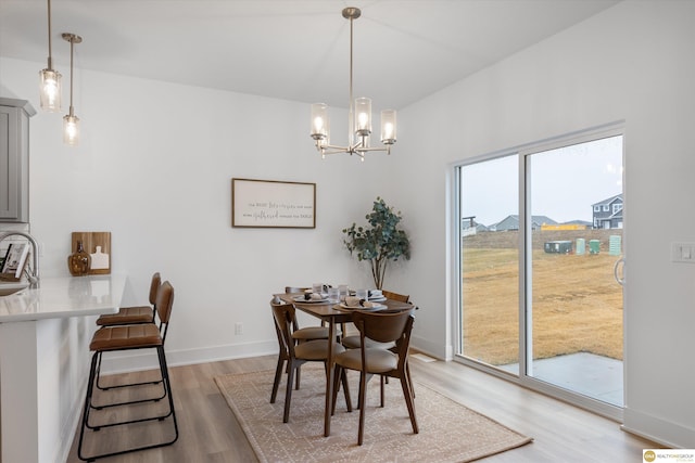 dining room featuring a chandelier, hardwood / wood-style floors, a healthy amount of sunlight, and sink