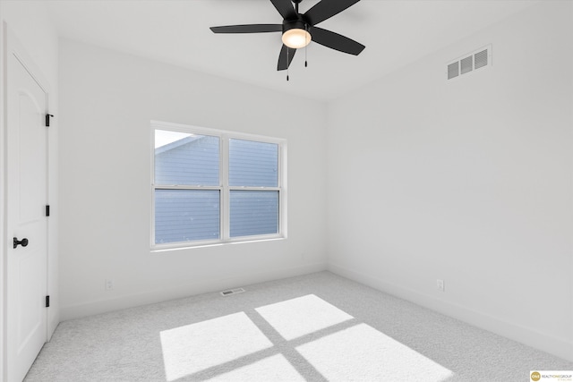 carpeted empty room with ceiling fan and a wealth of natural light