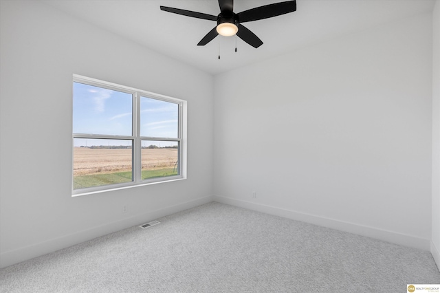 carpeted empty room with ceiling fan and a wealth of natural light