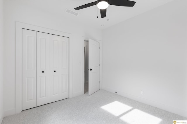 unfurnished bedroom featuring ceiling fan, a closet, and light carpet