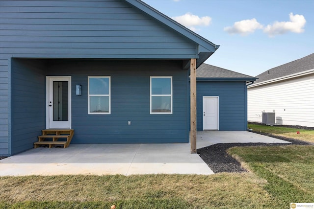 back of property featuring central AC unit, a yard, and a patio