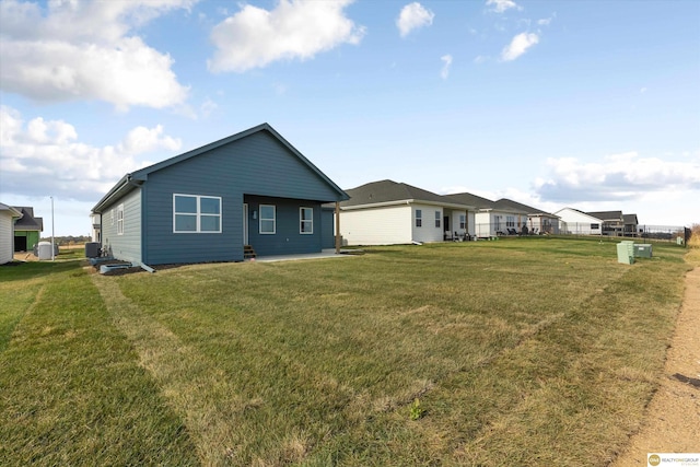 rear view of house featuring a yard