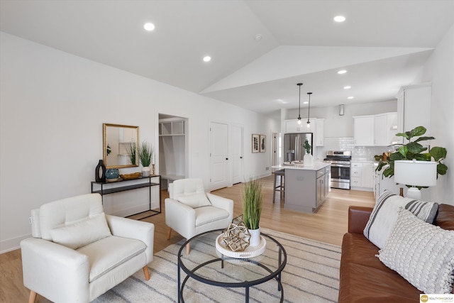 living room with light wood-type flooring and vaulted ceiling