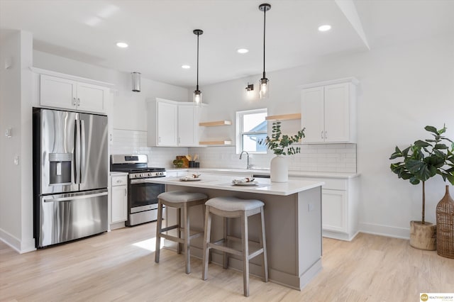 kitchen with a center island, white cabinetry, stainless steel appliances, and hanging light fixtures