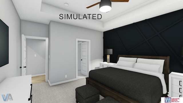 bedroom with ceiling fan, light colored carpet, and a tray ceiling