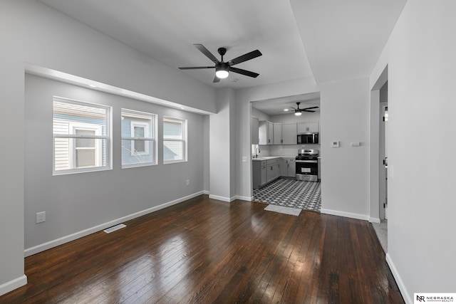 unfurnished living room with dark hardwood / wood-style floors, ceiling fan, and sink