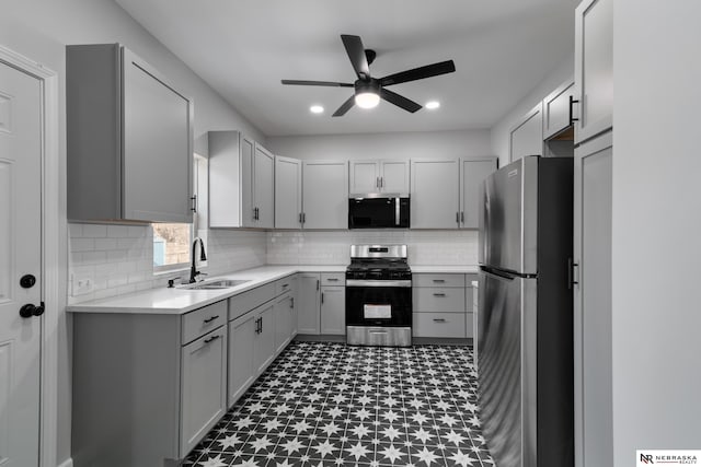 kitchen with appliances with stainless steel finishes, tasteful backsplash, gray cabinetry, ceiling fan, and sink