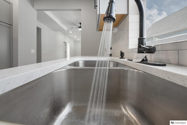 interior details with tasteful backsplash, light stone counters, and sink