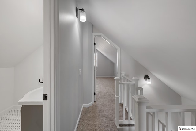 hallway featuring light carpet and lofted ceiling