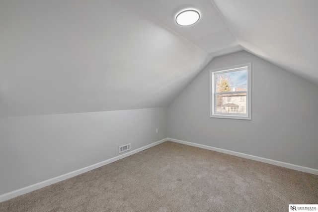 additional living space featuring lofted ceiling and carpet floors