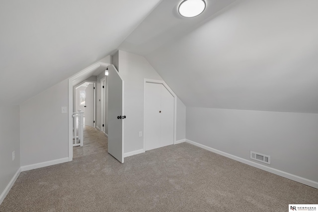 bonus room with light carpet and vaulted ceiling