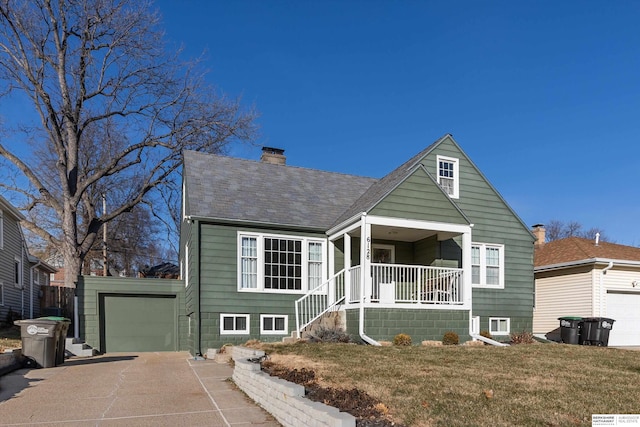 view of front of home with a front yard, a garage, and covered porch