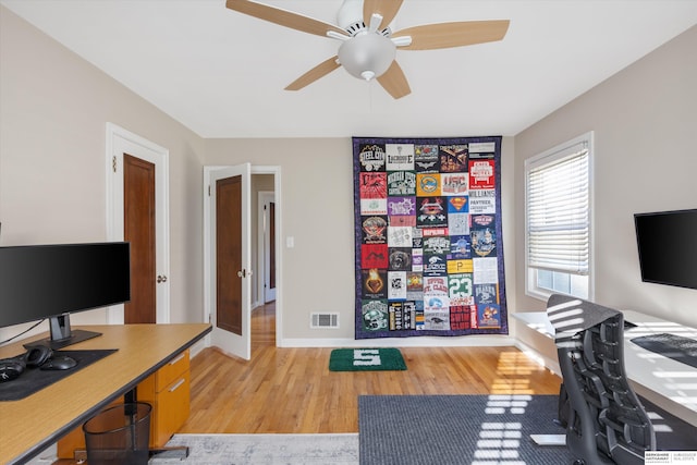 office with light wood-type flooring and ceiling fan