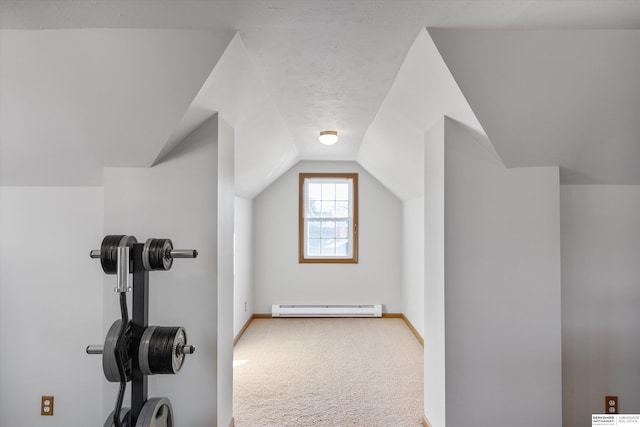 exercise room featuring baseboard heating, vaulted ceiling, and carpet flooring