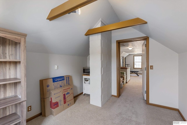 additional living space featuring light colored carpet and vaulted ceiling