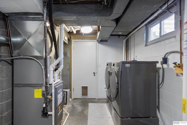 laundry room with heating unit and washing machine and clothes dryer