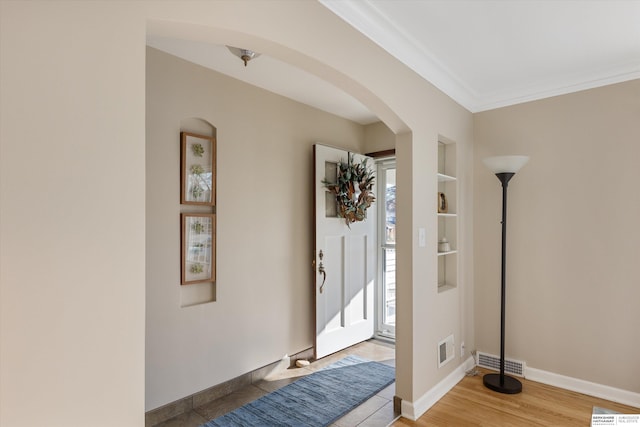 foyer with hardwood / wood-style flooring and crown molding