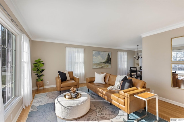 living room with light hardwood / wood-style floors, crown molding, and a chandelier