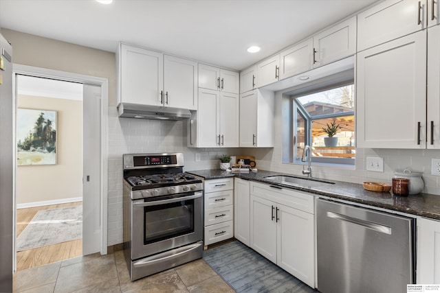 kitchen with sink, white cabinets, tasteful backsplash, and appliances with stainless steel finishes