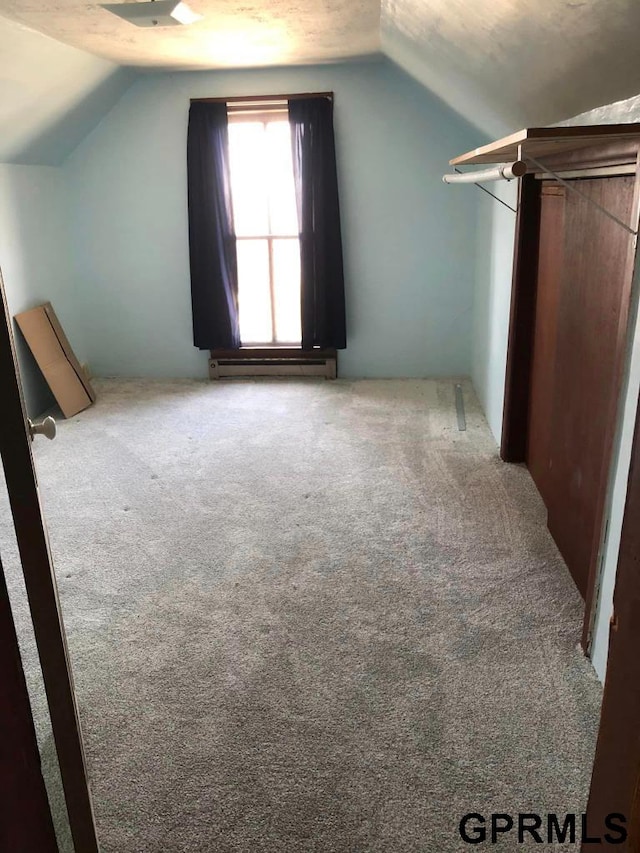 bonus room featuring carpet floors, vaulted ceiling, and baseboard heating