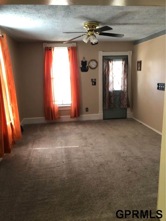 empty room featuring carpet flooring, a textured ceiling, and ceiling fan