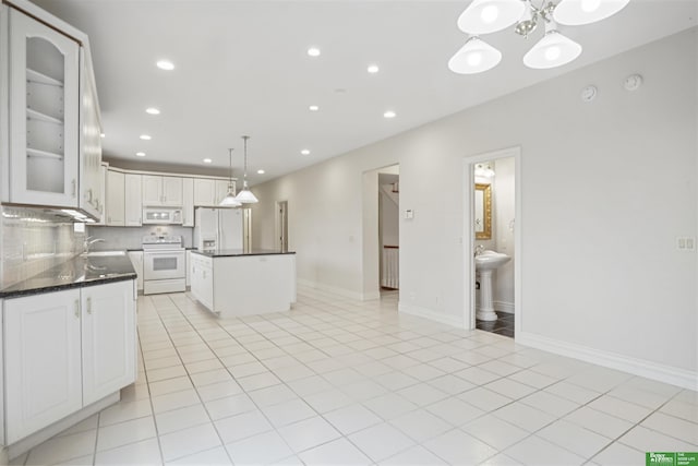 kitchen featuring a center island, light tile patterned floors, decorative light fixtures, white appliances, and white cabinets