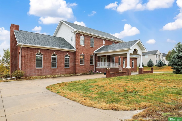 view of front of house featuring covered porch and a front yard